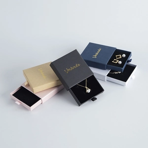 Macro shot of textured jewelry drawer boxes with gold foil logo and ribbon pulls