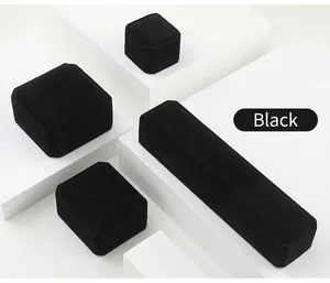 Set of black velvet jewelry boxes for rings and necklaces on geometric white stands