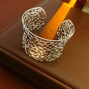 Close-up of irregular hollow silver cuff bracelet on luxury leather jewelry box stand