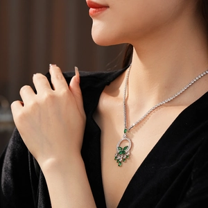 Détail du collier tennis argenté avec pendentif émeraude et gouttes de cristal sur modèle
