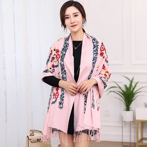 Detail of pink embroidered shawl with vibrant floral patterns and elegant fringe trim