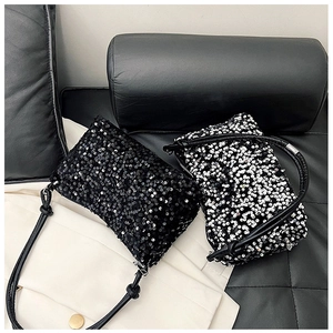 Detailed close-up showing the shimmering sequins and texture of black and silver handbags