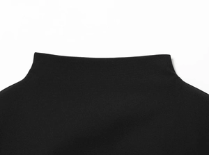 Macro detail of the black mock neck collar showing high-quality knitted fabric texture