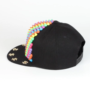 Detail der schwarzen Snapback-Cap mit Regenbogen-Silikonspikes und goldenen Nieten