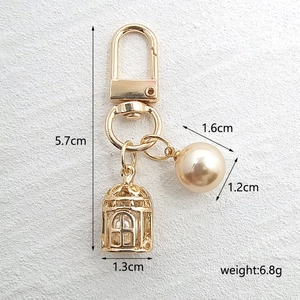 Detailed view of birdcage and pearl pendant charms with dimensions and 5.7cm height