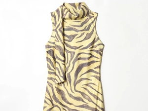 Detail of zebra print sleeveless dress with yellow and grey patterns and tie-neckline