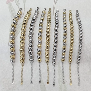 Detail view of steel bead bracelets with lobster clasps in gold and silver finishes