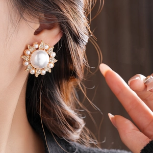 Detail of floral earring with large center pearl and sparkling crystals on model