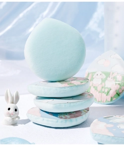Thick light blue velvet powder puffs with cute bunny and floral patterns on silk background