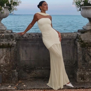 Close-up of cream off-shoulder dress featuring pleated mesh and semi-sheer layered hem