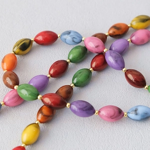 Gros plan de perles en acrylique marbré multicolore avec entretoises dorées