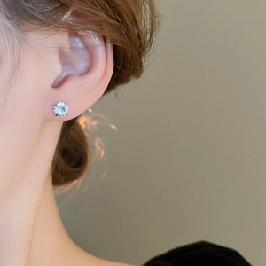 Close-up of a model wearing a classic silver stud earring with a brilliant round zircon