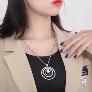 Close-up of a two-tone multi-layer circular pendant necklace with rhinestones on a model