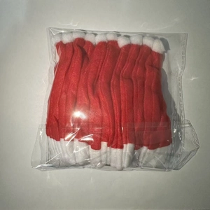 Close-up of mini red and white flannel Christmas hats for bottle decor and cutlery holders