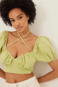 Detail of fruit green crop top with puff sleeves and criss-cross neck tie detail