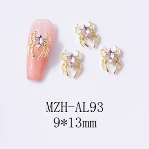 Macro detail of a 9x13mm gold spider nail art charm with pink marquise rhinestone