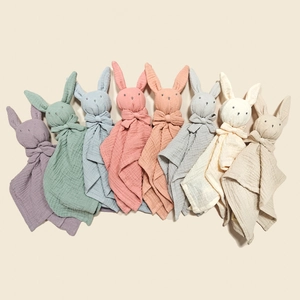 Flat lay of eight colorful muslin cotton baby security blankets with cute bunny heads
