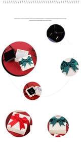 Detail of square jewelry gift box with textured paper, plush lining, and bow ribbon