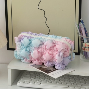 Detailopname van macaron gradiënt etui met zachte bubbeltextuur en een metalen ritssluiting