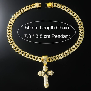 Detail view of 50cm gold Cuban chain and 7.8x3.8cm rhinestone cross pendant on black backdrop
