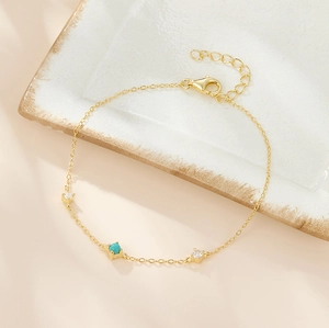 Macro shot of 925 silver gold bracelet with turquoise and zircon stones on stone tray