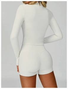 Rear view of white ribbed yoga set featuring long sleeve top and high waist shorts