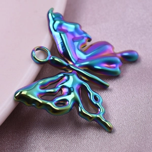 Macro shot of rainbow-plated hollow butterfly pendant on soft pink silk fabric background