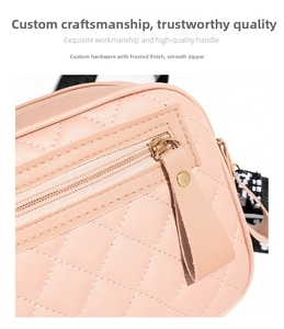 Detail of pink quilted camera bag featuring smooth gold hardware and leather zipper puller