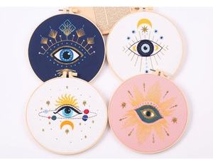 Detail of 4-piece embroidery kit with celestial eye patterns and metallic gold thread