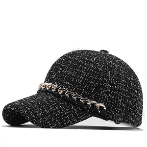 Detail of tweed fabric texture and decorative metal chain on this stylish baseball cap