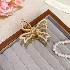 Elegant gold butterfly hair claw clip with inlaid pearls and metal cutout design