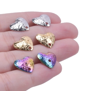 Macro view of heart-shaped stainless steel charms with mesh texture in three colors