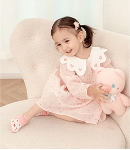 Close-up of pink non-slip baby socks with cartoon pig design worn by a toddler