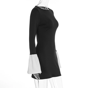 Detail of flared white cuffs on a slim black dress with a striking contrast design