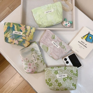Detail of five mini jacquard canvas pouches with floral patterns and zipper closure