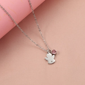 Elegant silver angel necklace with pink birthstone pendant on textured fabric