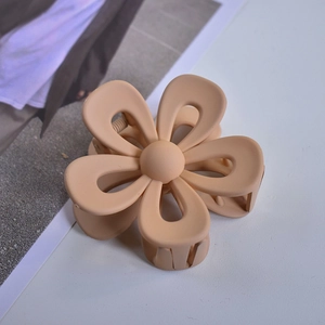 Detailed close-up of a beige flower claw clip with a matte finish on a clean surface