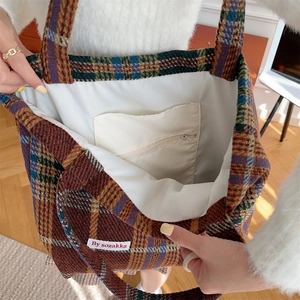 Detail view of large check tote bag interior showing white lining and zipper pocket
