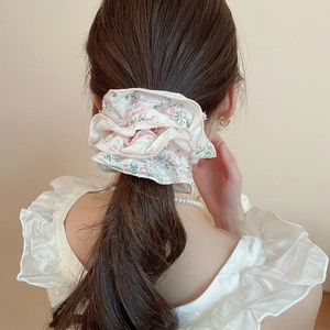 Oversized cream lace scrunchie with pink floral pattern worn on a ponytail hair