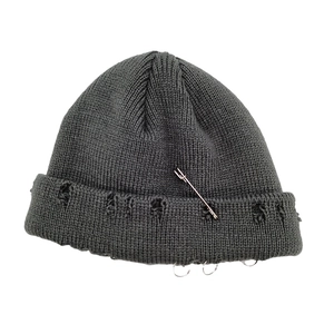Détail du bonnet en tricot gris foncé avec épingle de sûreté et trois anneaux en métal