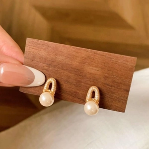 Elegant 18K gold plated pearl drop earrings with zircon crystals on dark wood display