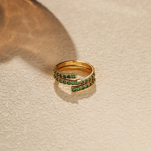 Macro shot of gold multi-layer wrap ring with emerald green zircon stones for women