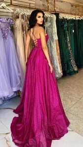 Detailed lace-up back design of a shimmering hot pink sequined evening gown with A-line skirt