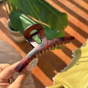 Close-up of tortoise shell pattern resin hair claw clip with sturdy metal spring