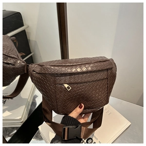 Detailed close-up of dark brown woven chest bag with front zipper and nylon strap