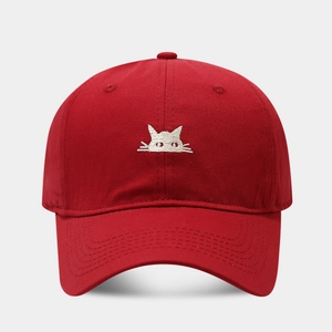 Close-up of a vibrant red cotton baseball cap featuring a white cat embroidery detail