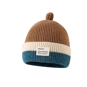 Three-color striped knit baby beanie with pom-pom and text label in brown and beige