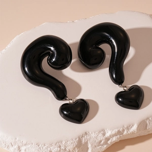 Close-up of black resin question mark earrings with hanging heart pendants for women
