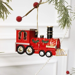 Festive red Christmas train ornament with gold wheels hanging on a holiday tree branch