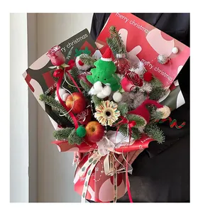 Detail of Christmas flower bouquet with red roses, apples, pine branches and festive paper